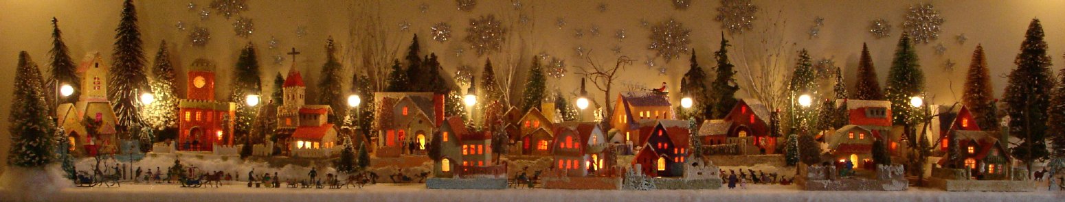 Antique Christmas cardboard house putz (village) on fireplace mantel at night (80K)