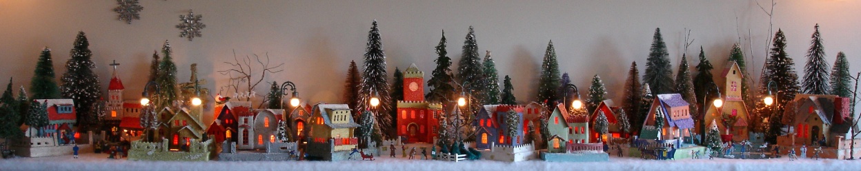 Antique Christmas cardboard house putz (village) on fireplace mantel at night (80K)