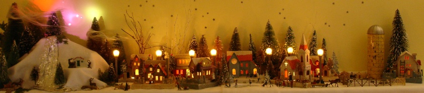 Antique Christmas cardboard house putz (village) on fireplace mantel at night (50K)