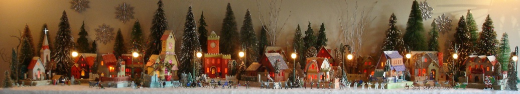 Antique Christmas cardboard house putz (village) on fireplace mantel at night (50K)