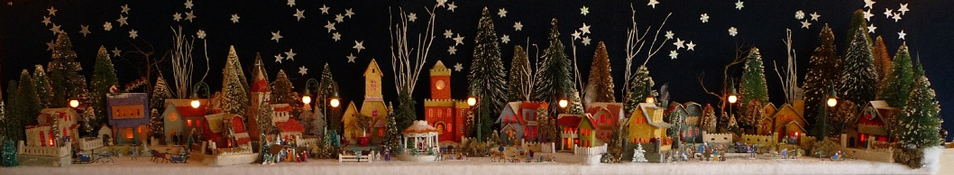 Antique Christmas cardboard house putz (village) on fireplace mantel at night (120K)